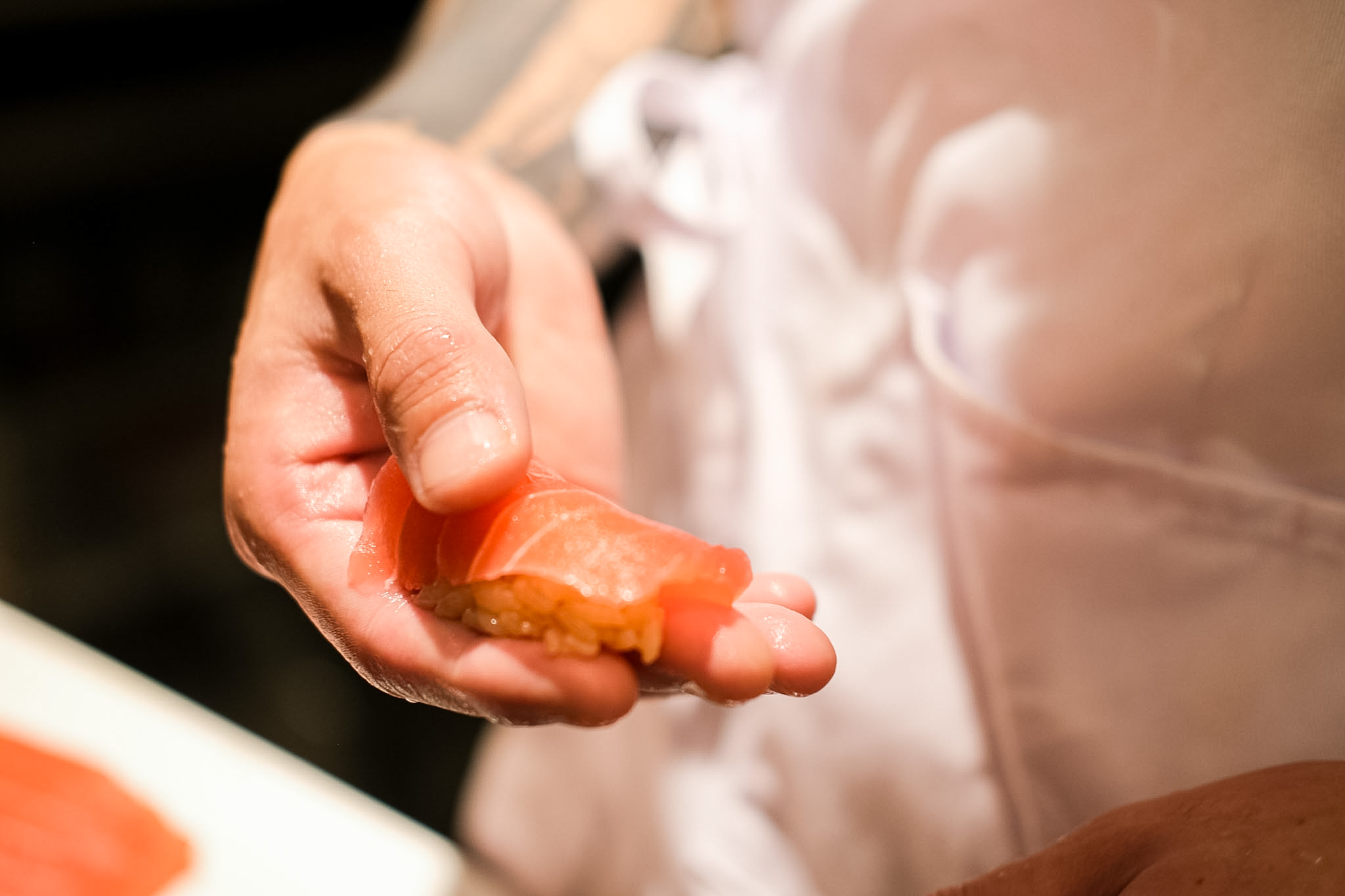 Close-up of a hand-formed nigiri held in the chef's palm