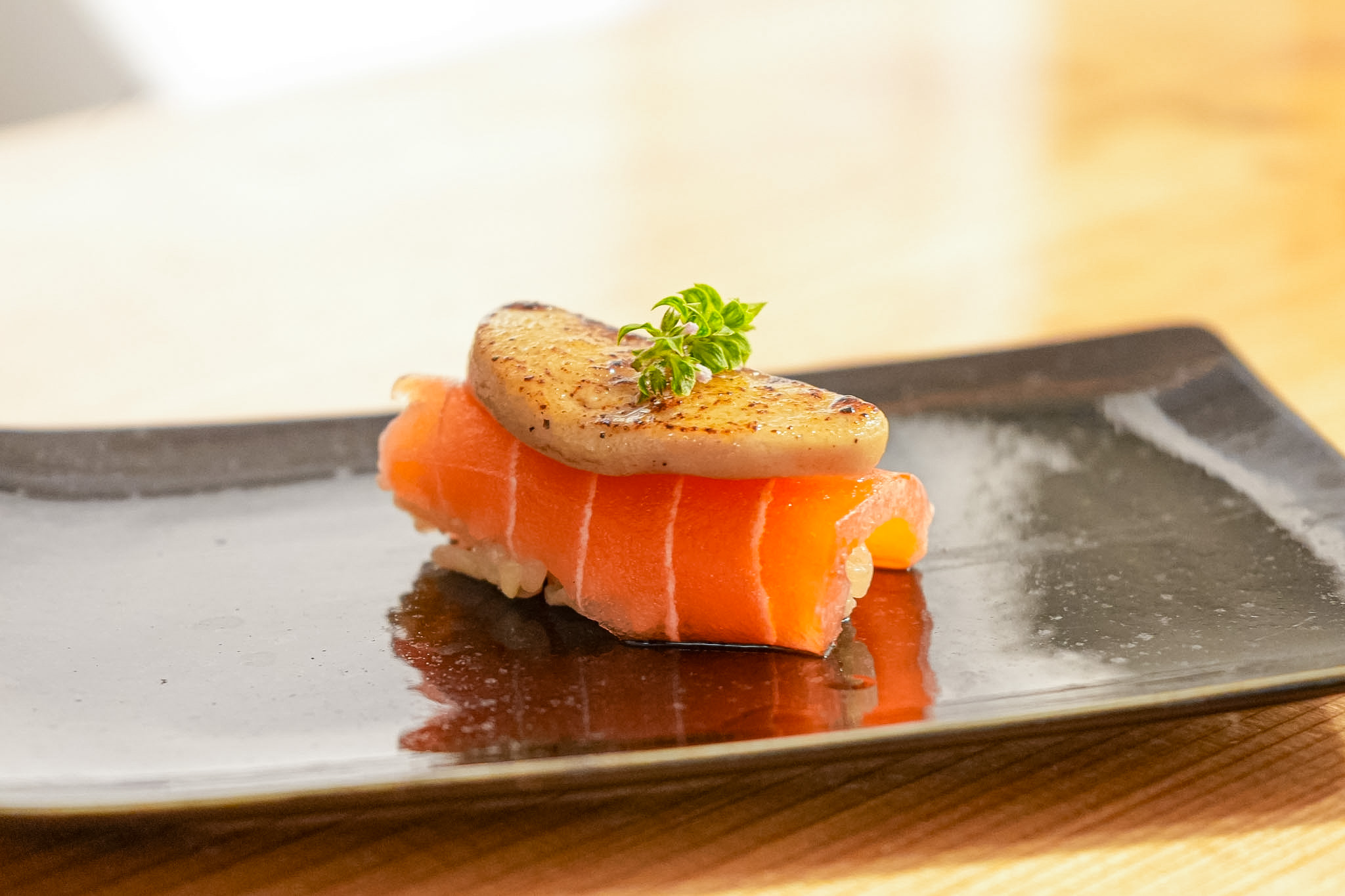 A nigiri topped with salmon and seared foie gras