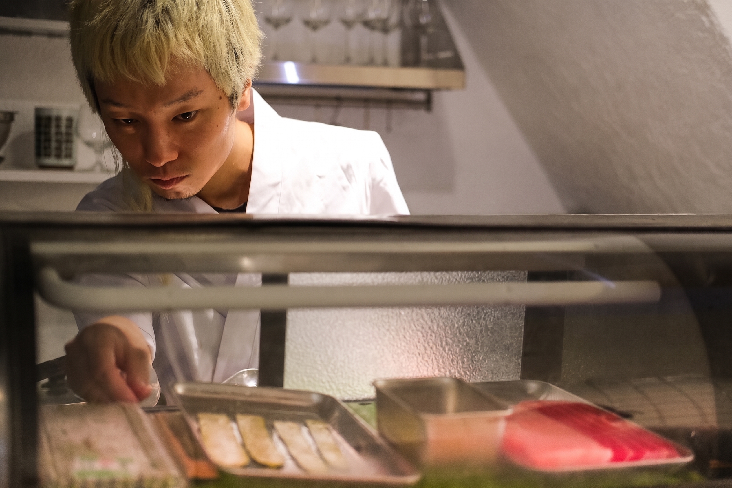 The chef preparing dishes behind the counter